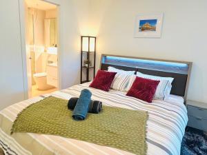 a large bed with red pillows and a green rug at Sweet Home Apartment North Melbourne in Melbourne