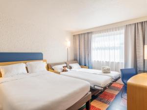 um quarto de hotel com duas camas e uma janela em B&B HOTEL Lyon Nord 4 étoiles em Dardilly