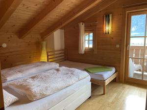 1 dormitorio con 2 camas en una habitación de madera en Chalet Descansa, en Neukirchen am Großvenediger