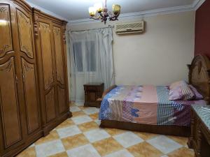 - une chambre avec un lit et une grande armoire en bois dans l'établissement Ramo City Stars Hotel, au Caire
