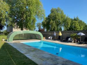 ein Schwimmbad mit grüner Brücke darüber in der Unterkunft Belle Dépendance du Château le Parc avec sa piscine in Ardentes