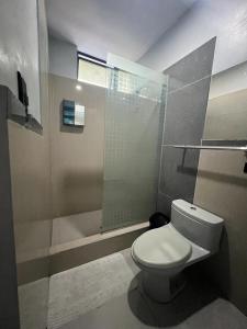 a bathroom with a toilet and a glass shower at Adrian´s Hotel in Pucallpa