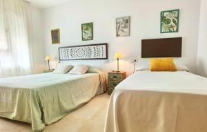 2 camas en una habitación con paredes blancas en Hostal Noray, en Sant Feliu de Guíxols