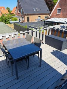 einen blauen Tisch und Stühle auf einer Holzterrasse in der Unterkunft Haus Windmühle Obergeschoß in Norden