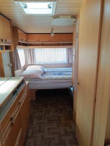 um pequeno quarto com uma cama e uma pequena cozinha em Camping Mauritius em Mielno