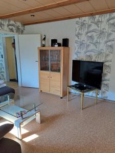 ein Wohnzimmer mit einem großen Flachbildfernseher in der Unterkunft Haus Windmühle Obergeschoß in Norden