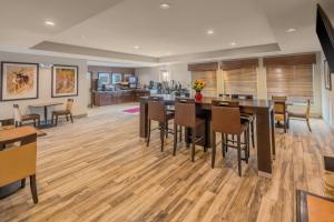 comedor con suelo de madera, mesas y sillas en Landmark Suites - Williston, en Williston