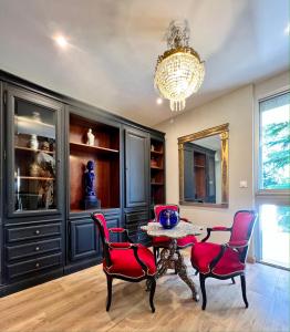 uma sala de jantar com uma mesa e cadeiras e um lustre em Villa Pauline em Avignon