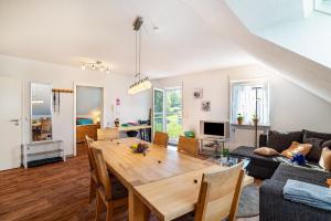 a dining room and living room with a wooden table at Schwalbenhof Dreßler und Duss für 6 in Bad Herrenalb