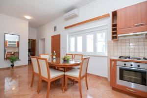 伊莫茲基的住宿－Apartment Petra，厨房以及带桌椅的用餐室。