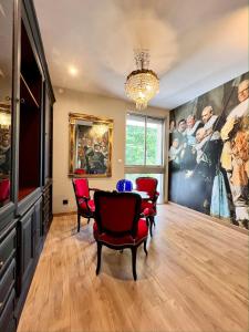 una sala da pranzo con tavolo, sedie e un grande dipinto di Villa Pauline ad Avignone