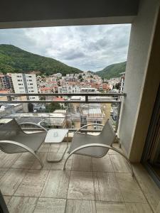 a balcony with chairs and a view of a city at Jovana ianua in Budva