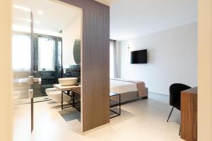 1 dormitorio con cama, mesa y baño en BLUETTE SUITE & BOAT, en Polignano a Mare