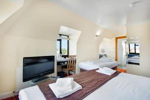 Un dormitorio con dos camas y un televisor de pantalla plana. en The Brent Hotel - London - Wembley, en Londres 31 fotos más