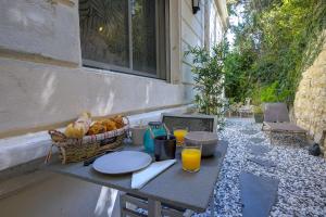 a table with a basket of food and orange juice at Jacuzzi, Mer 3 min, B&B in Nice