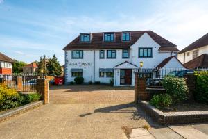 una casa blanca con techo marrón en The Brent Hotel - London - Wembley, en Londres