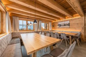 a dining room with a wooden table and chairs at Poolchalet Dachsteinblick in Pruggern