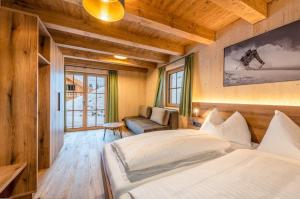 a bedroom with two beds and a couch in it at Poolchalet Dachsteinblick in Pruggern