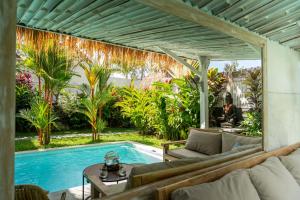 sala de estar al aire libre con piscina y pérgola en Villa Piece Of Peace private 3BR with large pool and garden, en Canggu