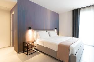 1 dormitorio con 1 cama grande y mesa auxiliar en BLUETTE SUITE & BOAT, en Polignano a Mare