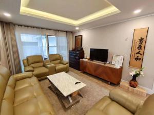 a living room with a couch and a tv at 芭提雅市中心4间卧室泳池别墅好莱坞Hollywood旁-19 in Pattaya Central
