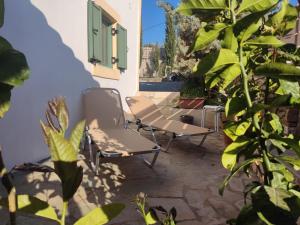 a patio with two chairs and some plants at DESPOSIA Karavas in Kythira