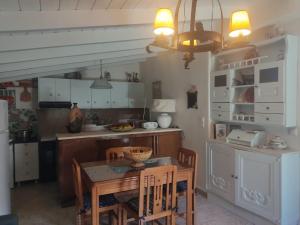 eine Küche mit Tisch und Stühlen und ein Esszimmer in der Unterkunft DESPOSIA Karavas in Kýthira