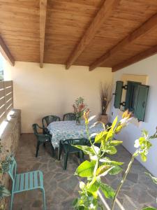 a patio with a table and chairs and a wooden ceiling at DESPOSIA Karavas in Kythira