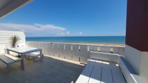 d'un balcon avec une table et une vue sur la plage. dans l'établissement Residence Luna, à Lignano Sabbiadoro