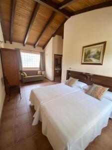 a bedroom with two beds and a couch at Hotel rural Monasterio de Ara Mada in Santa Colomba de las Arrimadas