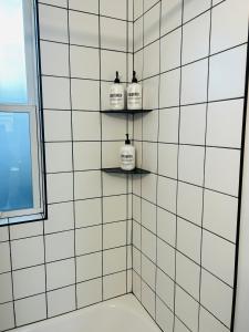 a bathroom with three bottles on shelves on the wall at North End Bungalow 1921 Half in Boise