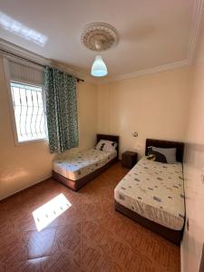 a room with two beds and a window with at Hay mohammadi agadir in Agadir