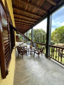 eine Terrasse mit Stühlen und einem Tisch auf dem Balkon in der Unterkunft Villa calme - Jardin Tropical - Kpalimé in Palimé