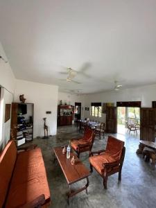 sala de estar con sofá, sillas y mesa en Villa calme - Jardin Tropical - Kpalimé, en Palimé