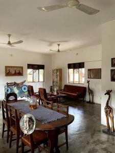 una sala de estar con mesa, sillas y estatuas de jirafa en Villa calme - Jardin Tropical - Kpalimé, en Palimé