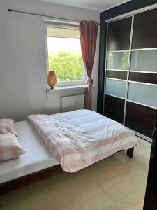 łóżko w sypialni z oknem w obiekcie Piękny apartament blisko Malty z garazem w Poznaniu