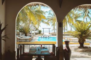 a view of a pool through an archway at a resort at Mambo Ocean Resort in Pwani Mchangani