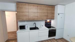 a white kitchen with a sink and a microwave at ADRIATIC APARTMENT center II MAKARSKA in Makarska