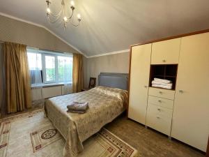 1 dormitorio con 1 cama, vestidor y ventana en Гостевой дом en Shchūchīnsk