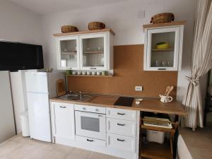 a kitchen with white cabinets and a white refrigerator at Apartment Stipe in Donja Klada