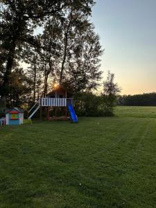 a playground with a slide in the middle of a field at Hof Baden, Ferienwohnung in Schneverdingen