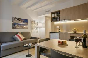 sala de estar con sofá y mesa con copas de vino en Ola Living Vidreria, en Barcelona