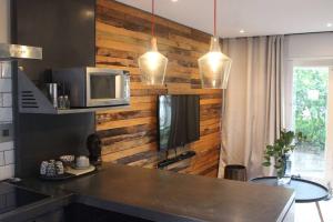 a kitchen with a counter with a microwave and a tv at Well Appointed Apartment by ARPA Hospitalities in Stellenbosch