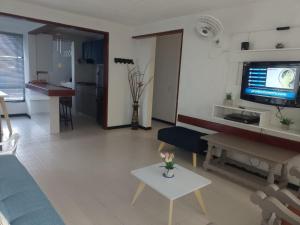 a living room with a couch and a table and a tv at Apartamento San José in Melgar