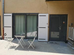 two chairs and a table in front of a building at Proche Hôpital LyonSud Metro B Calme et WiFi in Pierre-Bénite