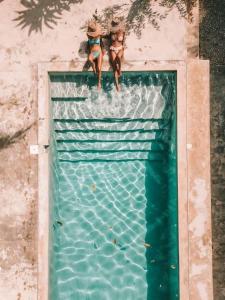 dos muñecas están sentadas en la parte superior de una piscina en Residencia El Balatà, en Las Terrenas
