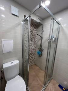 a bathroom with a toilet and a glass shower at Cozy and bright apartment in Sofia
