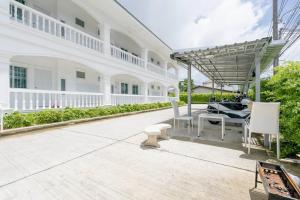 a patio of a white house with a table and chairs at White House Apartment - Chalong in Chalong 