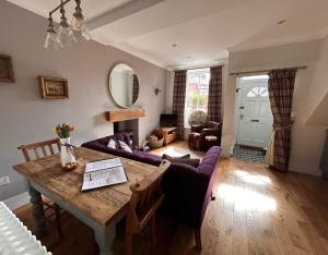 a living room with a table and a purple couch at The Cottage in Dunblane