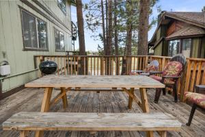una mesa de picnic de madera en una terraza junto a una casa en BURRO SPRINGS - Close to Lake and Slopes, en Big Bear City